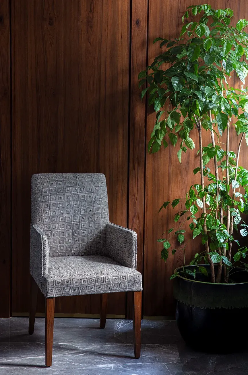 A grey armchair against fluted wood at The Healing Centre