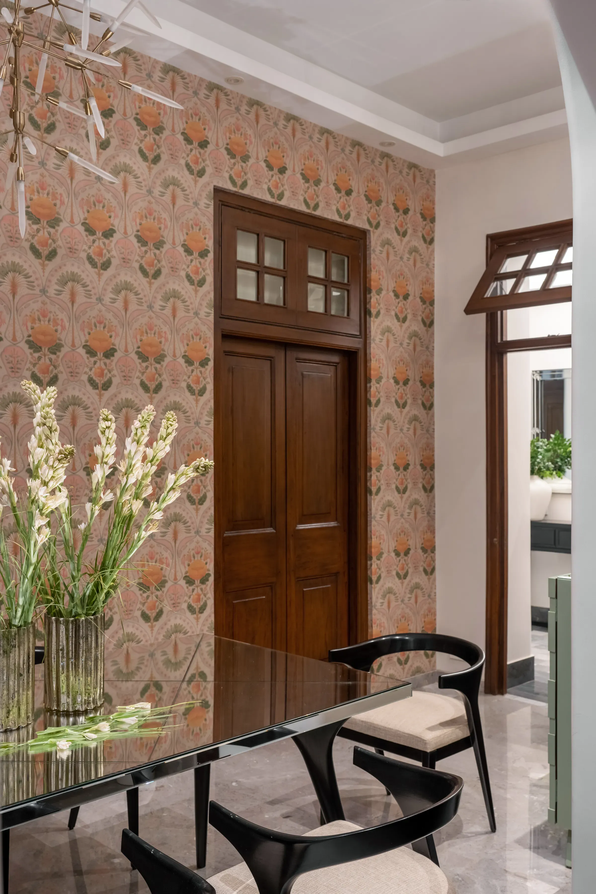 The mirrored dining table against block-printed wallpaper