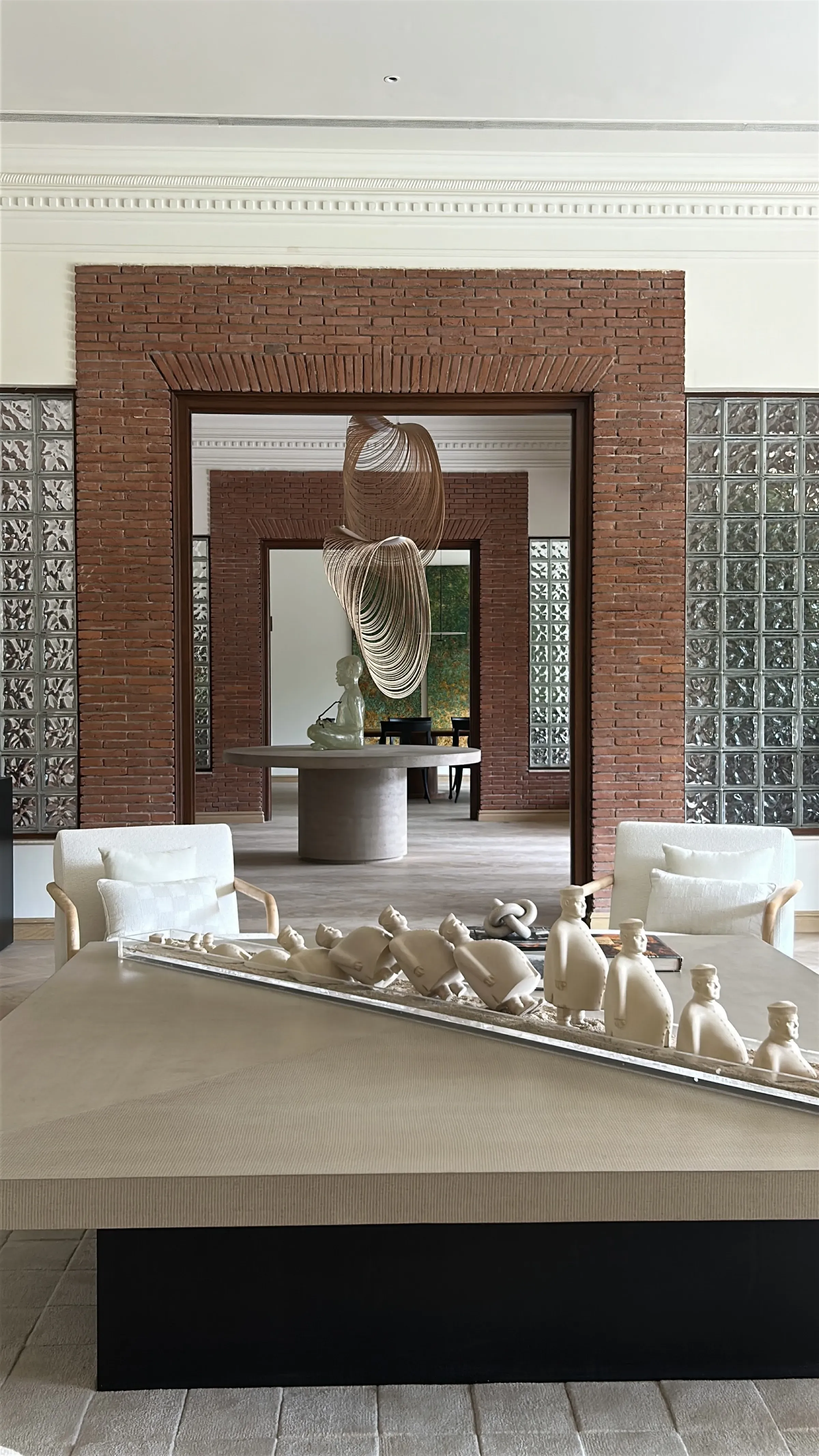 Brick entrance with figurines and pendant sculpture at the Delhi farmhouse