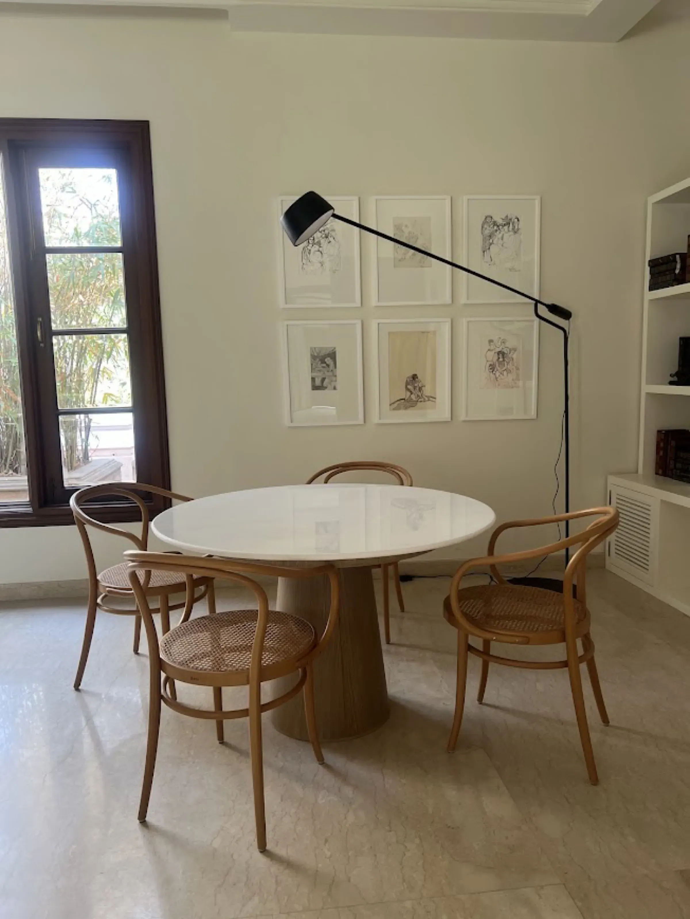 Reading nook with bentwood chairs and sketches at the Delhi farmhouse